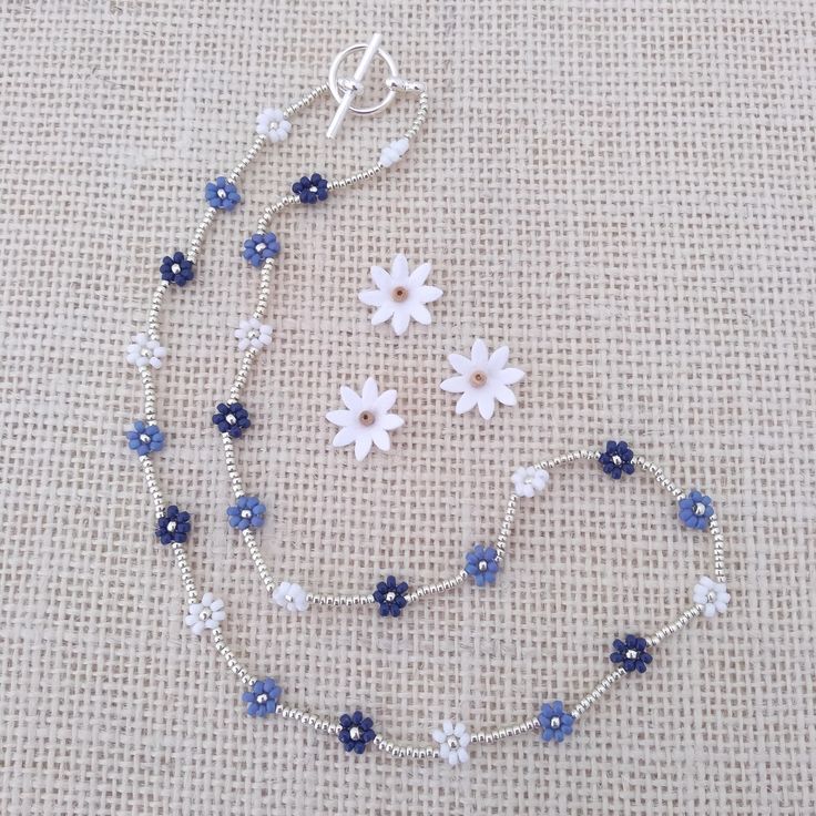 I made this pretty 16" daisy necklace using quality glass seed beads in white, blue and navy with tiny silver glass beads in between.  The necklace is finished with a silver plated toggle clasp. Daisy Beaded Necklace, Diy Jewelry Projects, Diy Jewelry Unique, Blue Beaded Bracelets, Blue Beaded Necklace, Beading Jewelery, Beaded Jewlery, Bead Charms Diy, Beaded Necklace Diy