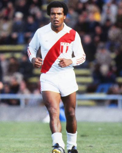 a soccer player is running with the ball in his hand and people are watching from the stands