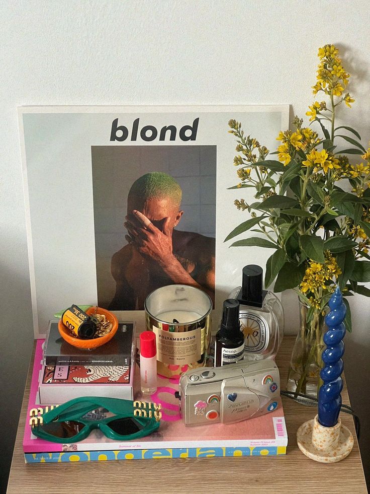 a wooden table topped with lots of items and a vase filled with flowers on top of it