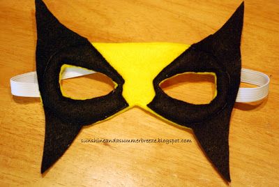 a black and yellow cat mask sitting on top of a wooden table