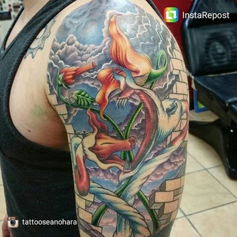 a man with a dragon tattoo on his arm and shoulder is shown in this photo