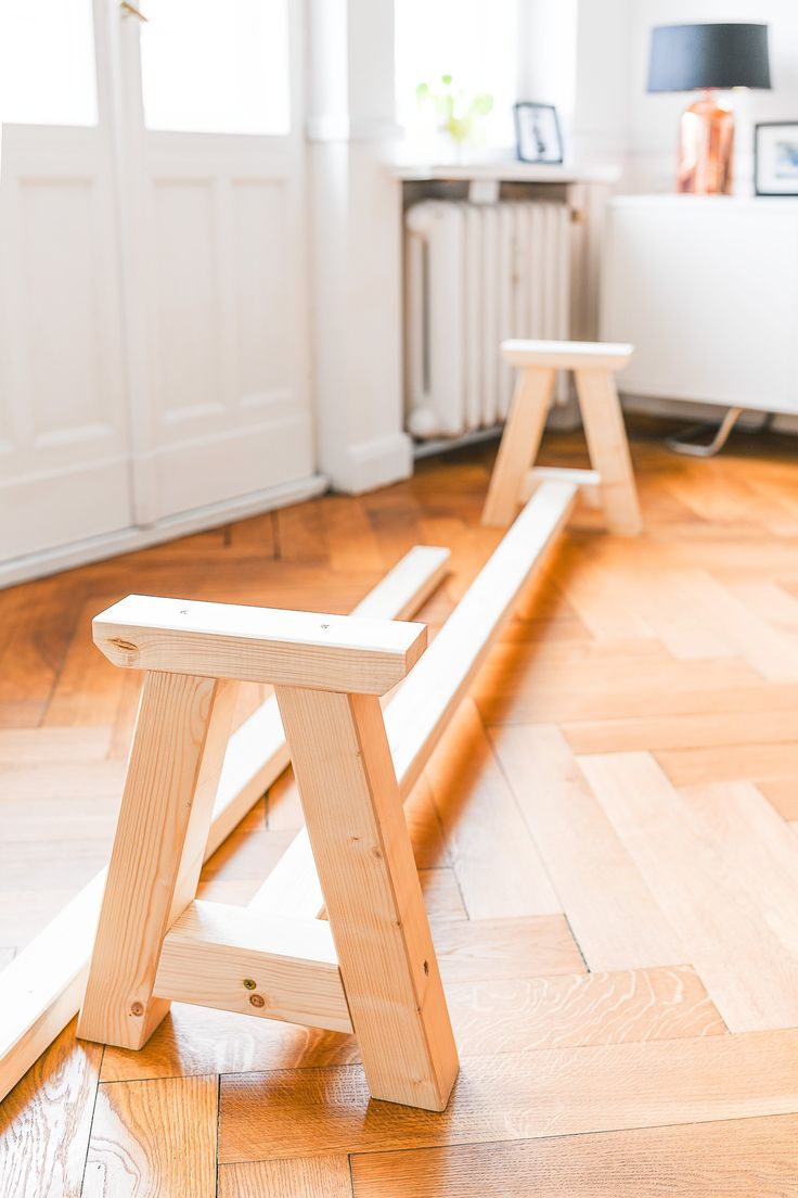 a wooden bench sitting on top of a hard wood floor