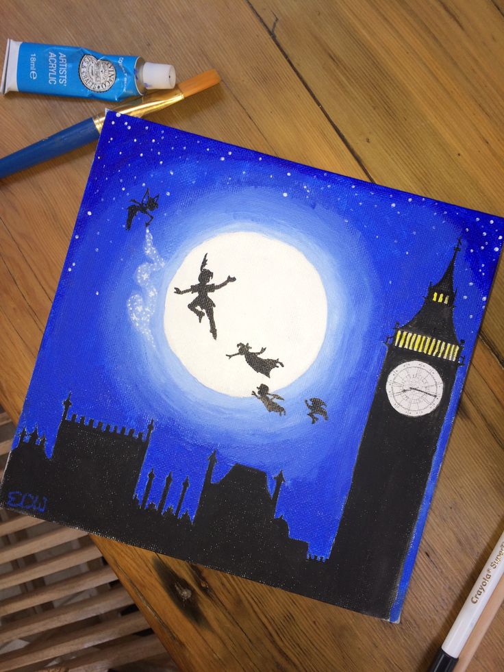 an art project with acrylic paint and markers on a wooden table next to a clock tower