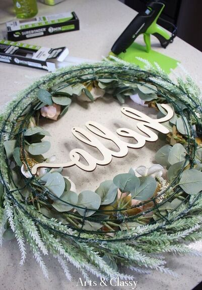 a wreath that has the word class spelled on it and some greenery around it