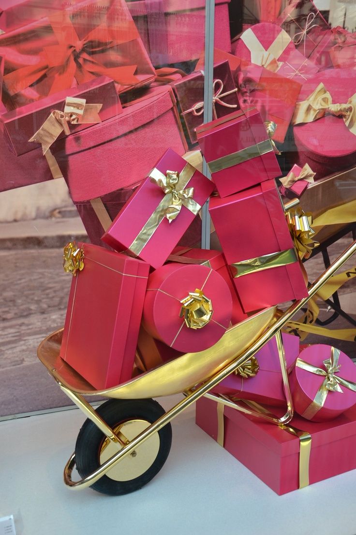 a cart filled with pink and gold wrapped presents