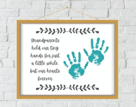 a frame hanging on a brick wall with an image of two hands and the words grandparents hold