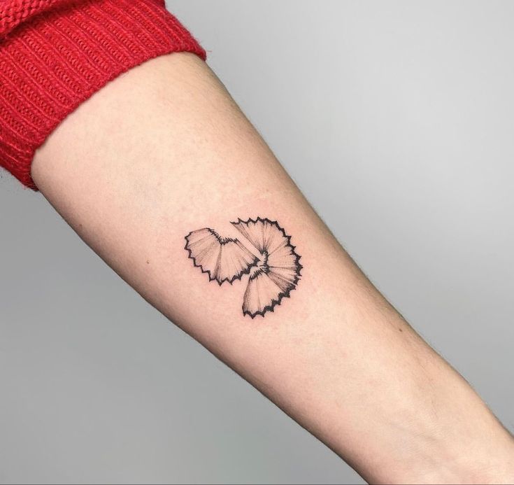 a woman's arm with a black and white butterfly tattoo on the left forearm