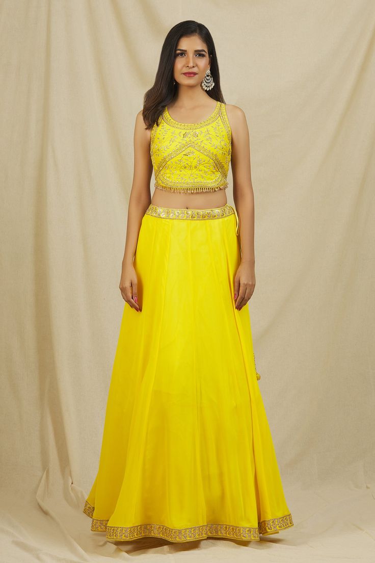 Yellow georgette lehenga with attached can-can and embroidered borders. Paired with round neck padded blouse with all floral pattern zari, sequin, cut dana, bead embroidery and stone work dupatta.
Components: 3
Pattern: Embroidered
Type Of Work: Sequin, Pearl, Zari and Cut Dana Work
Neckline: Round Neck
Sleeve Type: Sleeveless
Fabric: Georgette
Color: Yellow
Other Details: 
Bead tasselled blouse hem
Curved blouse hem
Criss-cross back
Lehenga Closure: Side tasselled tie-up
Occasion: Sangeet,Mehen Blouse Lehenga, Tassel Blouse, Georgette Lehenga, Padded Blouse, Hem Blouse, Stone Work, Fashion App, Beaded Tassels, Bead Embroidery