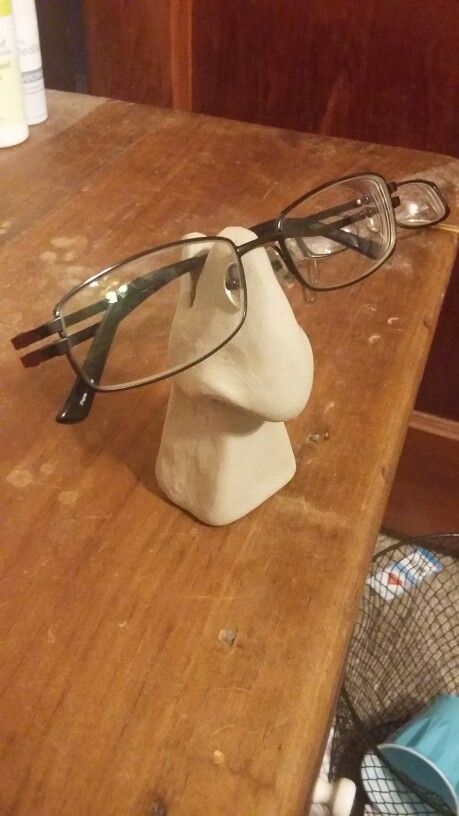 a pair of glasses sitting on top of a wooden table next to a plastic mannequin head