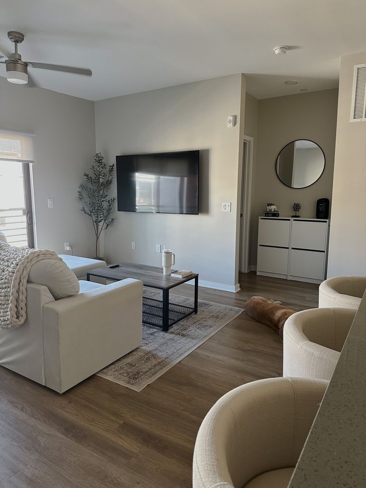 a living room filled with furniture and a flat screen tv mounted to the side of a wall