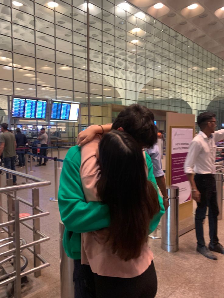 two people hugging each other in an airport