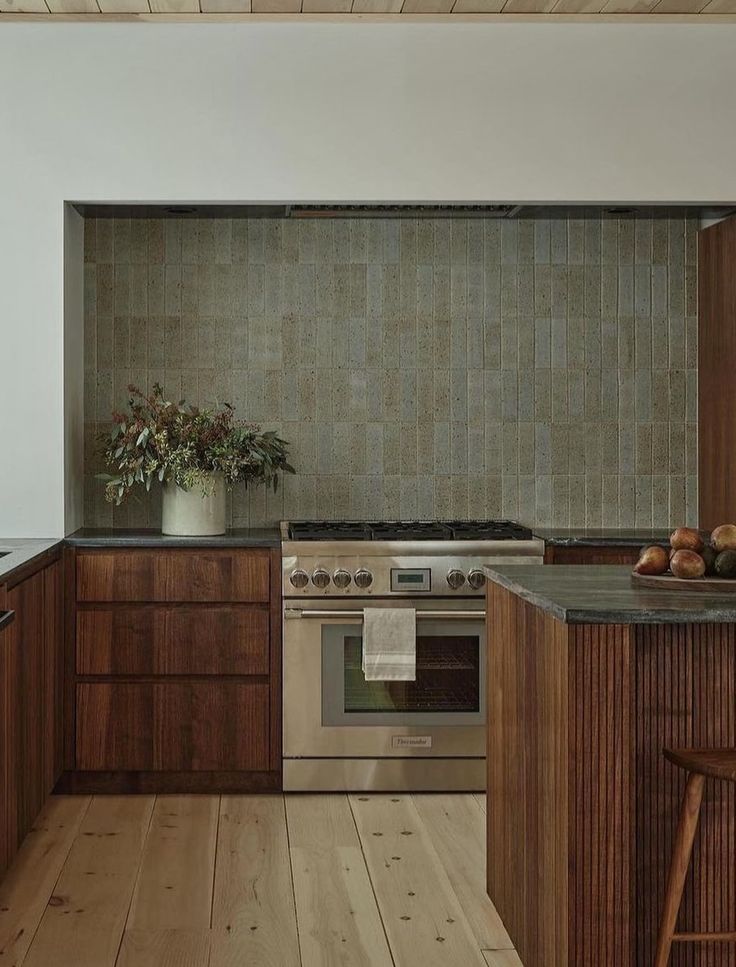 a kitchen with wooden cabinets and stainless steel stove top oven, wood flooring and counter tops