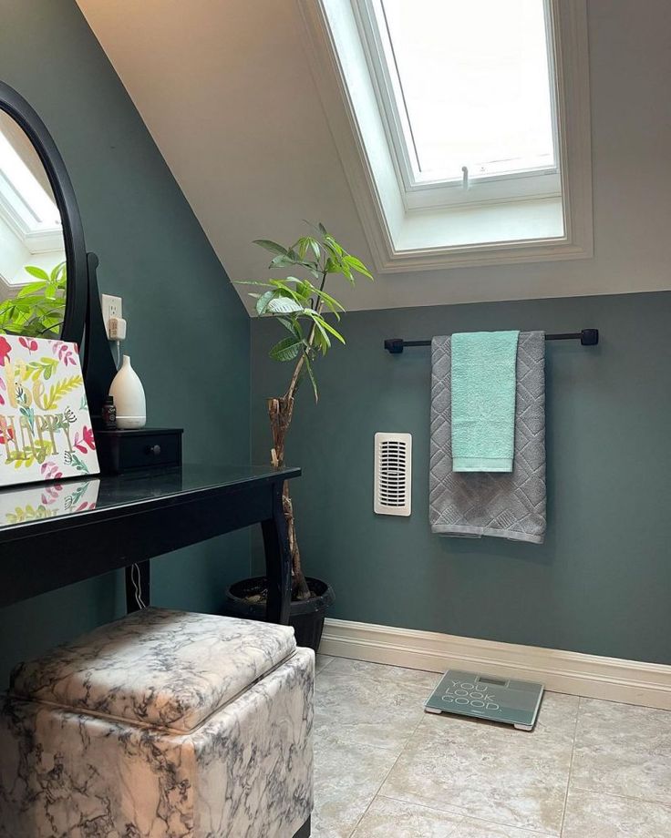 a bathroom with blue walls and white tile on the floor, along with a plant