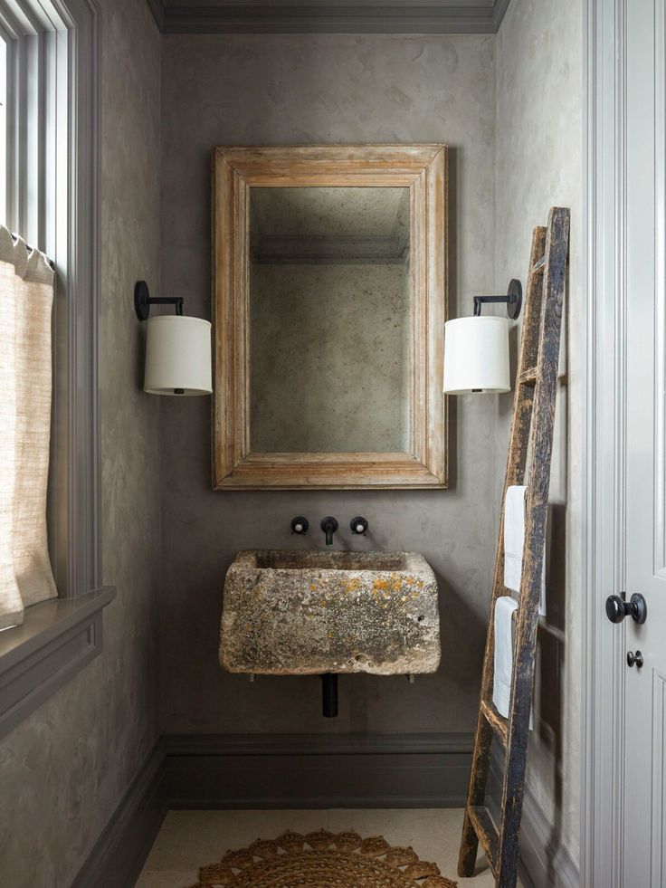 a bathroom with a mirror, sink and ladder