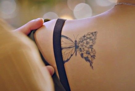 a woman with a butterfly tattoo on her back