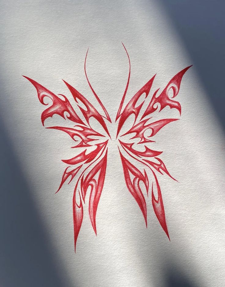 a red and white butterfly painted on the side of a sheet of paper with shadow