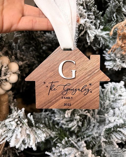 a wooden ornament with the letter g on it hanging from a christmas tree