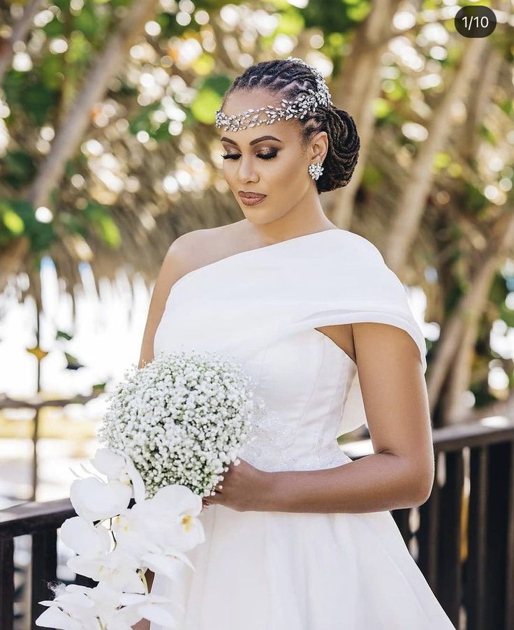 a woman in a white dress holding a bouquet of flowers and wearing a tiara