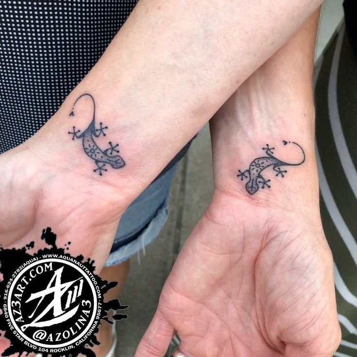 two people with matching tattoos on their hands holding each other's hand and one has a lizard tattoo on it