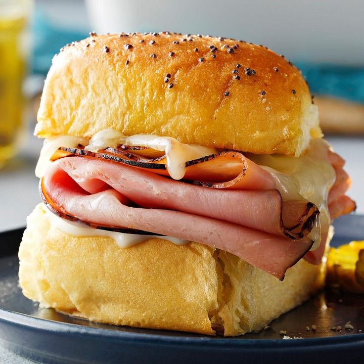 a ham and cheese sandwich sitting on top of a black plate