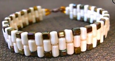 a white and brown beaded bracelet on a gray surface with the words beads written below it