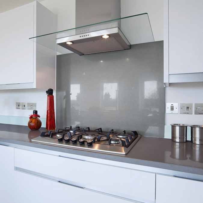 a stove top oven sitting inside of a kitchen next to white cabinets and counter tops