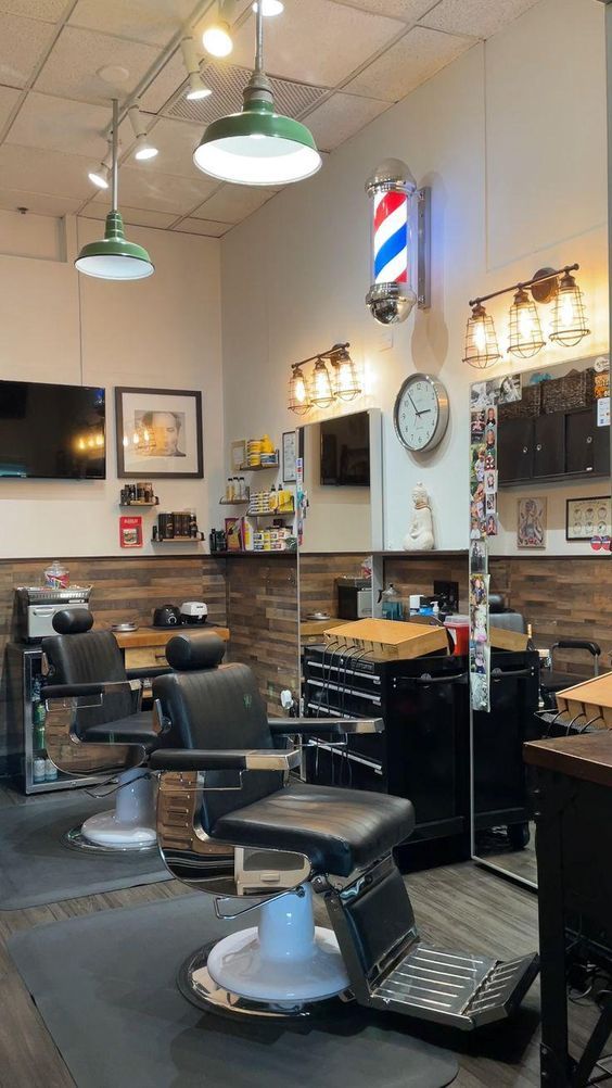 a barber shop with chairs and lights on the ceiling