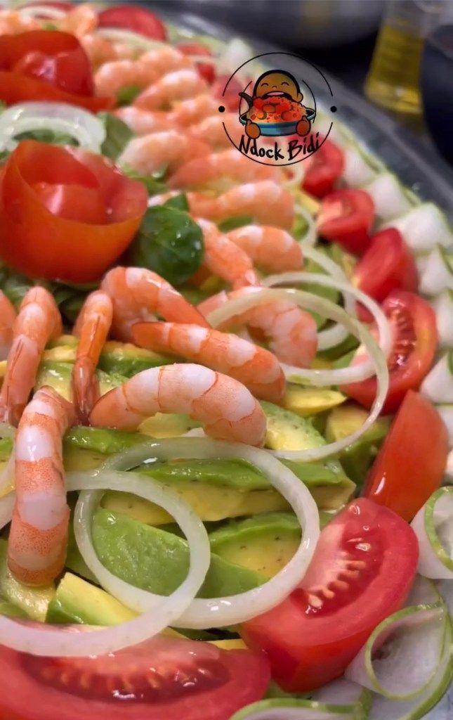 a platter with shrimp, tomatoes, cucumbers and onion slices on it