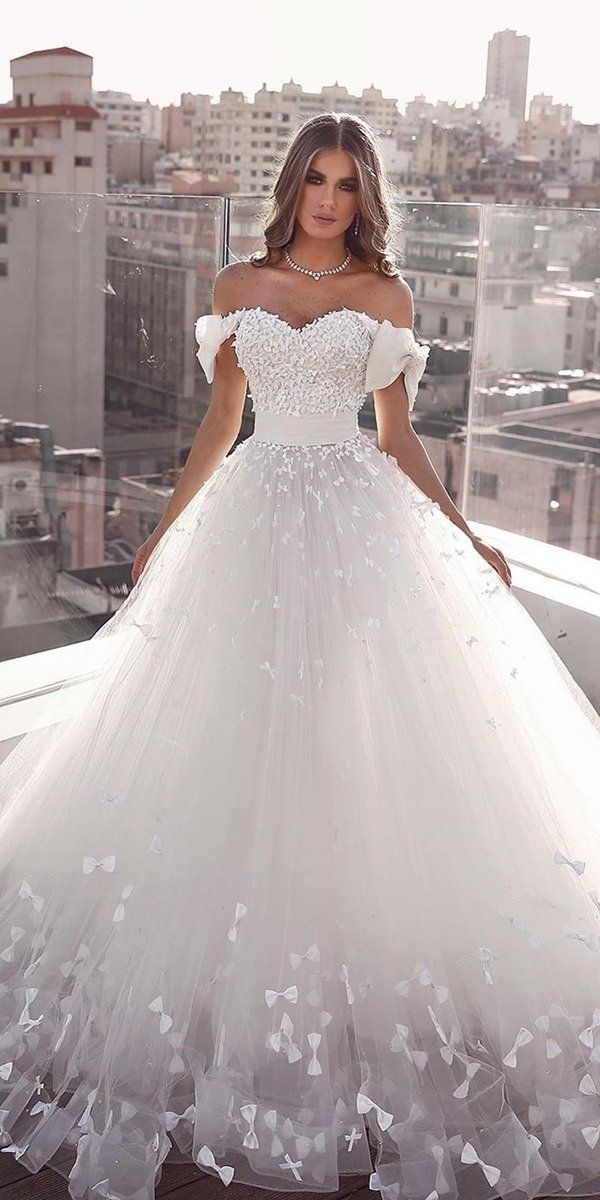 a woman in a white wedding dress standing on a balcony