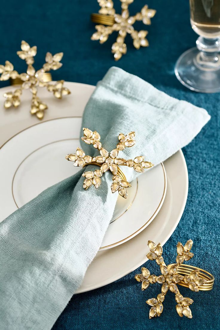 a white plate topped with gold snowflakes on top of a blue table cloth