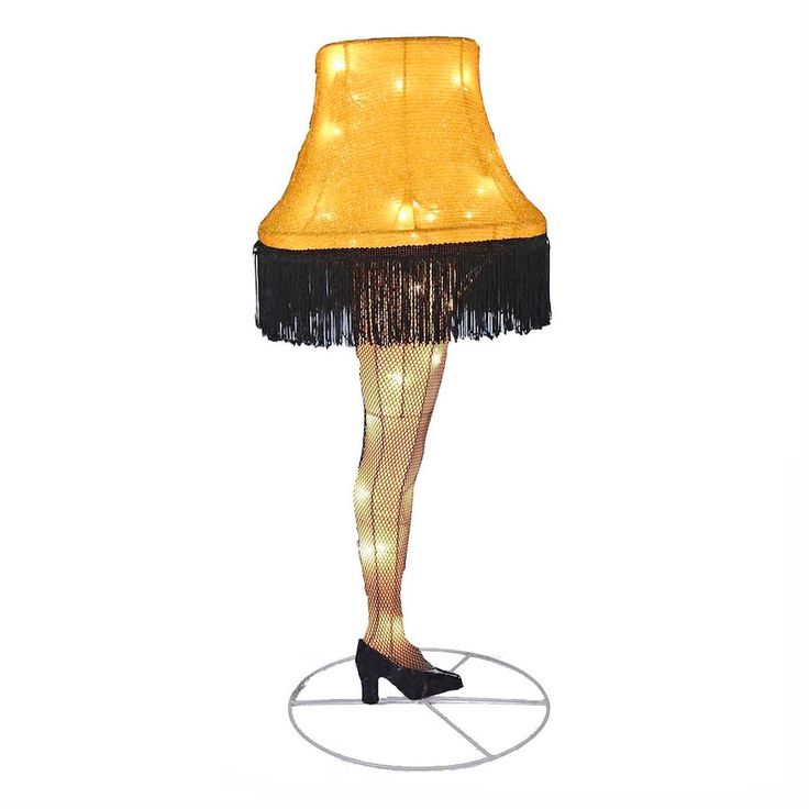 a lamp that is sitting on top of a round base with a black fringe around it