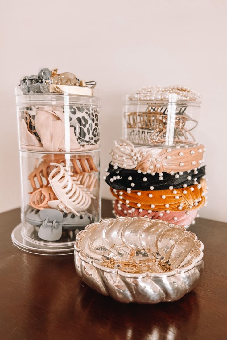 there are many different types of bracelets in the glass containers on the table next to each other