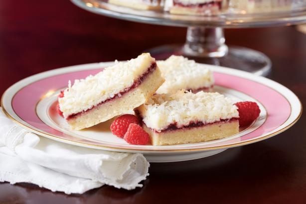 raspberry shortbreads on a pink plate with white frosting and crumbs