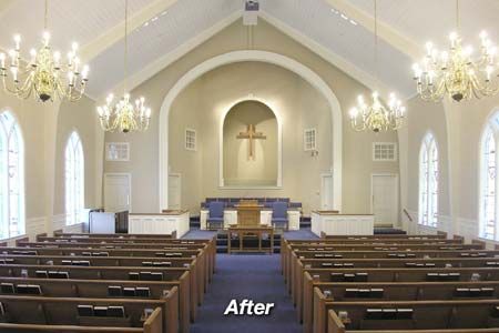 an empty church with pews and chandeliers