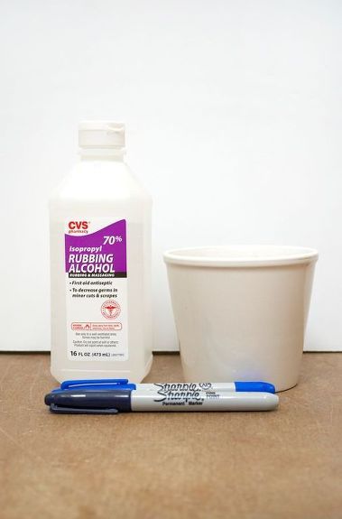 a cup, pen and container sitting on a table