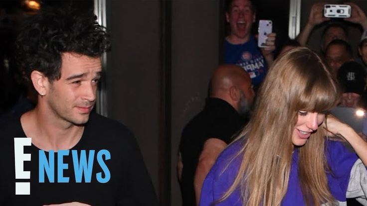 a man and woman are walking through a crowd with cell phones in their hands, one is wearing a t - shirt that says news