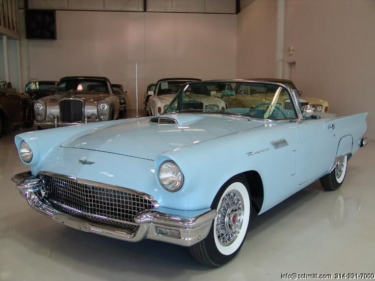 an old blue car parked in a garage