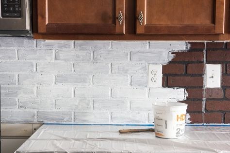 a bucket of paint sitting on top of a counter next to a microwave and cabinets