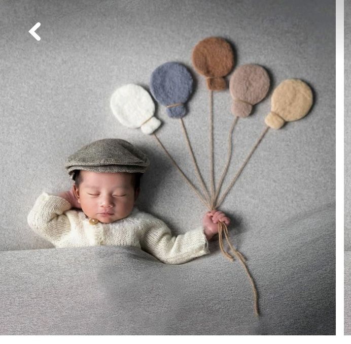 a baby is sleeping on a couch with balloons attached to the back of his head