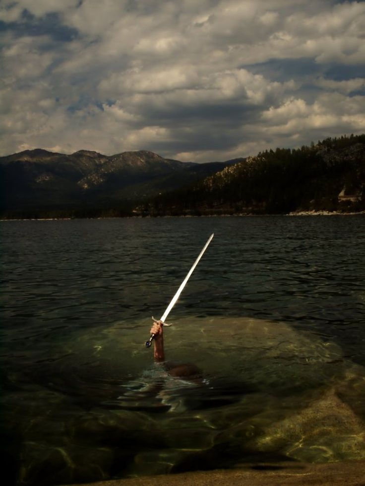 a person in the water with a long white pole sticking out of their head and holding onto something