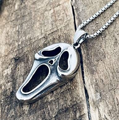 a silver necklace with an animal's face on it sitting on a wooden surface