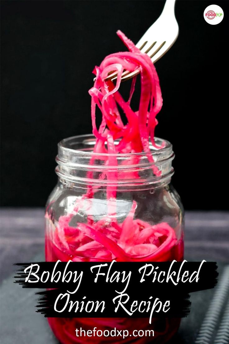 a fork sticking out of a mason jar filled with red onion rings and shredded onions