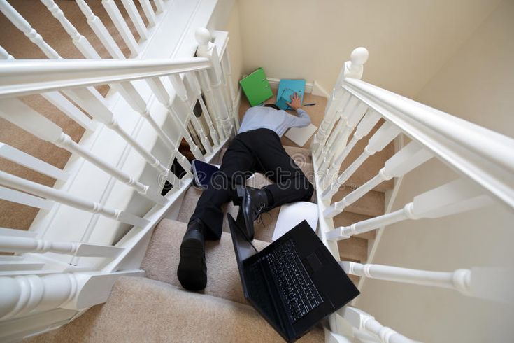 a person laying down on the stairs with their feet up and laptop in front of them