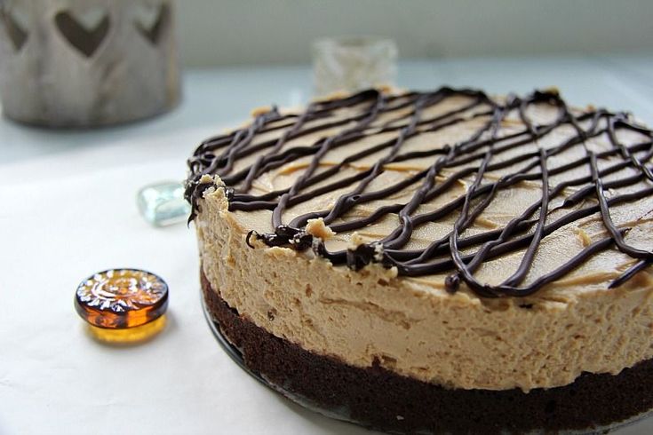 a cake with chocolate frosting and drizzled on top sitting on a table