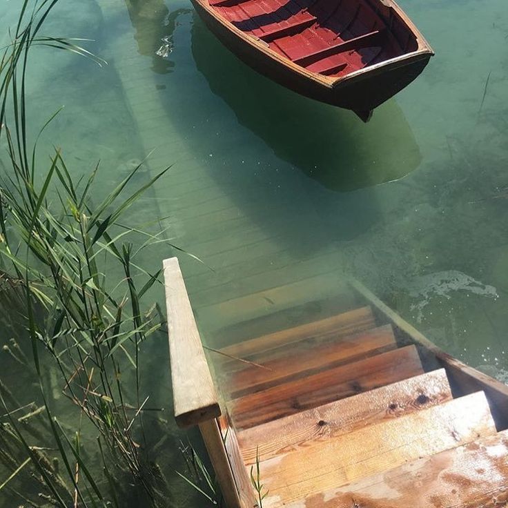 a small boat floating on top of a body of water next to a wooden dock