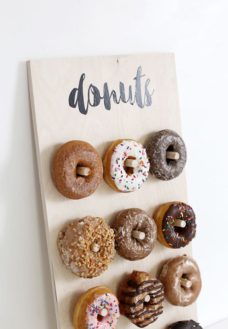 a wooden sign that says donuts on it and six different types of doughnuts