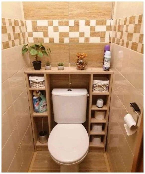 a white toilet sitting inside of a bathroom next to a wooden shelf filled with items