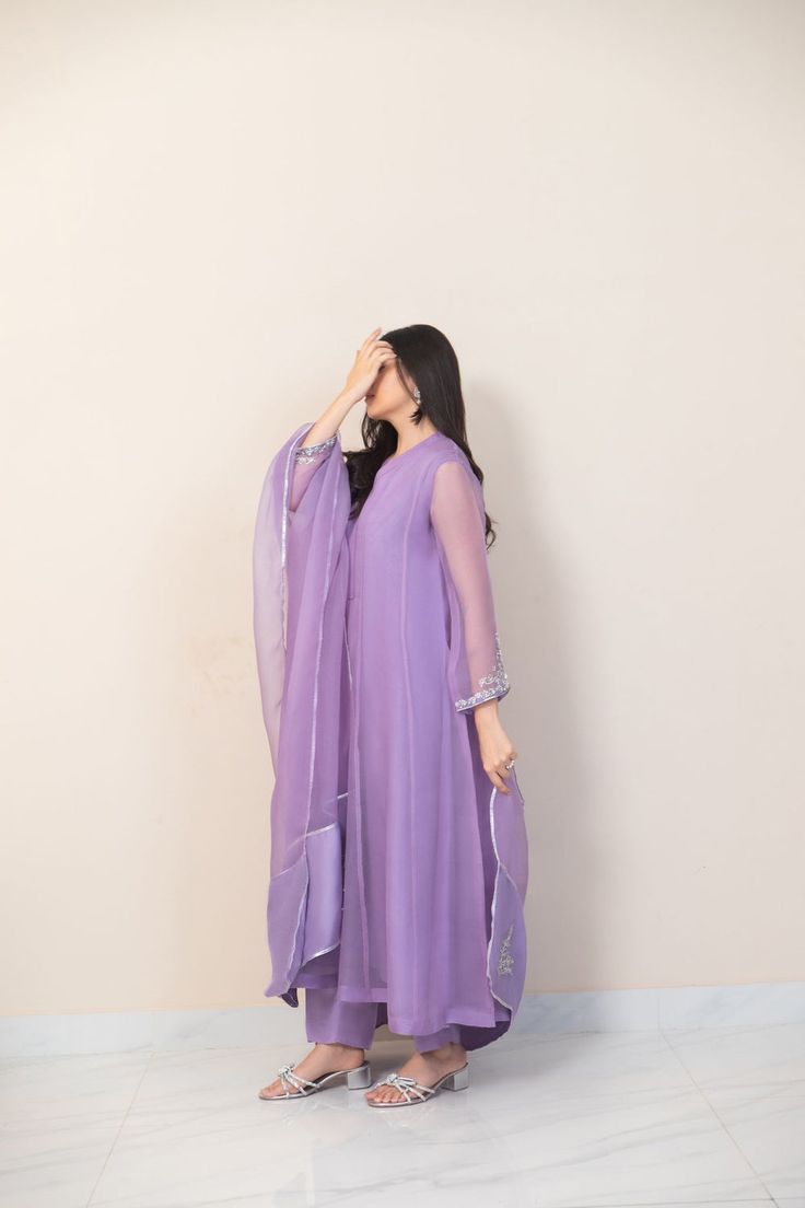 This beautiful three piece is designed on pure lilac organza heavily embellished with pretty floral threadwork, styled with a matching organza dupatta featuring gotah accents and straight trousers with motifs. The length of the long kameez is 47 inches. Shade number 4144 Order Duration: 4 to 6 weeks Semi-stitched Purple Georgette Palazzo Set, Purple Georgette Palazzo Set With Straight Kurta, Purple Palazzo Set With Dabka Work And Straight Kurta, Unstitched Lavender Sets For Eid, Purple Mirror Work Palazzo Set For Eid, Purple Designer Lawn Suit With Straight Kurta, Elegant Purple Palazzo Set With Resham Embroidery, Bollywood Style Purple Palazzo Set With Dupatta, Purple Bollywood Palazzo Set With Dupatta