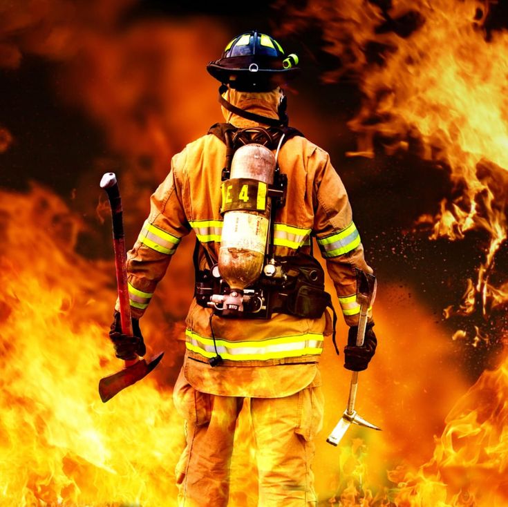 a firefighter standing in front of a blazing background