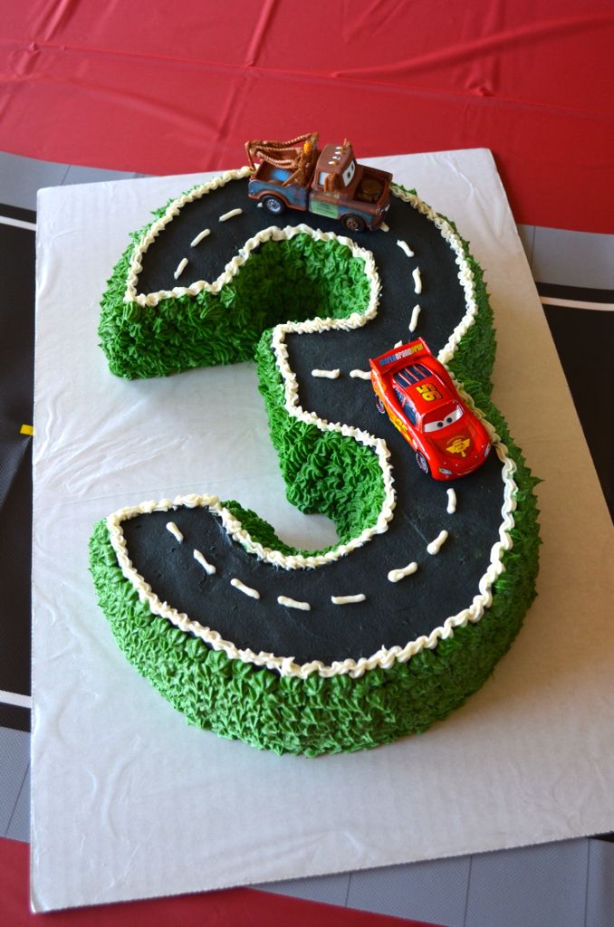 a cake shaped like the number three with cars on it